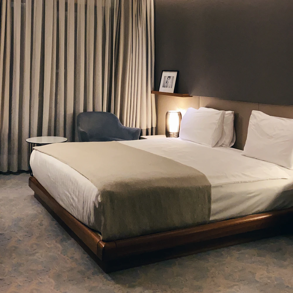 Hotel room turned down with the bedside lamp left on for a late arrival